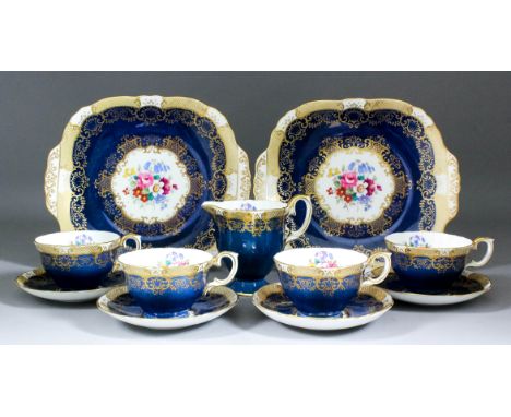 An early 20th Century Crown Staffordshire part tea service printed and overpainted in colours with a floral design and a blue