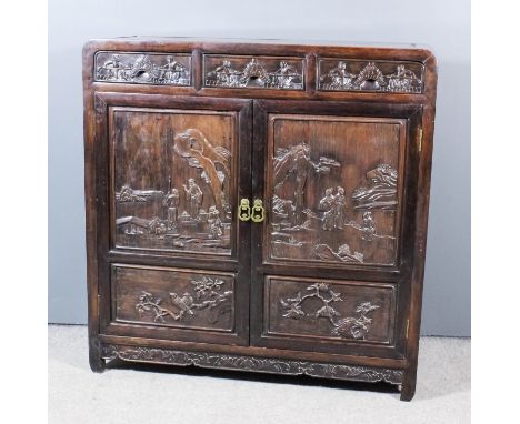 A Chinese panelled hardwood cabinet with flush panelled top and sides, the front fitted three frieze drawers and shelf enclos