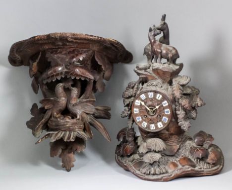 A 19th Century "Black Forest" carved wood cased mantel clock, the 4.25ins diameter carved wood dial inset with Roman numeral 