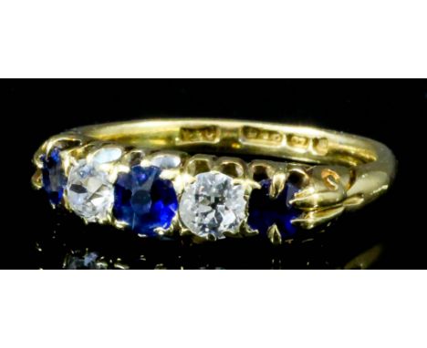 A late Victorian 18ct gold mounted five stone sapphire and diamond ring, set with three old cut sapphires interspersed by two