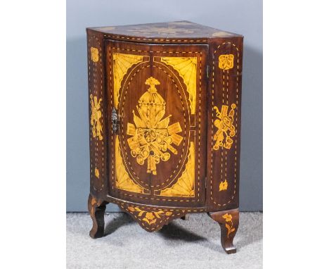 A Dutch mahogany dwarf bow front corner cabinet, the whole inlaid with musical trophies, fan and ribbon ornament and chequere