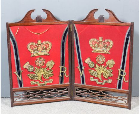 A late 19th / early 20th Century mahogany framed two-fold fire screen inset to both sides with four Victorian scarlet jacket 
