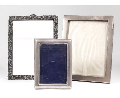 An early 20th Century sterling silver rectangular photograph frame with engine turned ornament, 9.5ins x 7.5ins overall, an E
