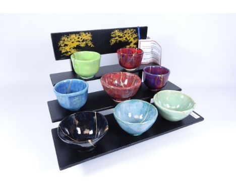 Set of eight bowls with Kintsugi Art design, on display shelf, H28cm    Condition Report   Click here for further images, con