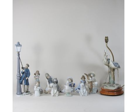 A large Lladro porcelain figure of a lamplighter, 48cm high, together with Nao porcelain figures and a table lamp in the form