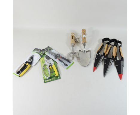 A stainless steel hand trowel and fork, together with a set of three trimming shears, and three pairs of secateurs