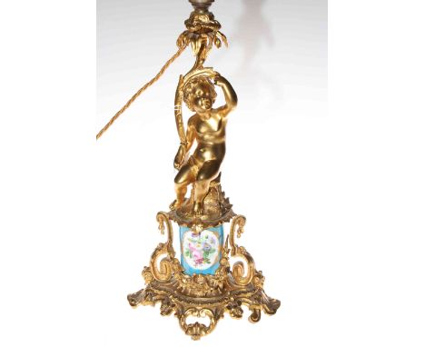 Ornate gilt metal and porcelain lamp base decorated with cherub.