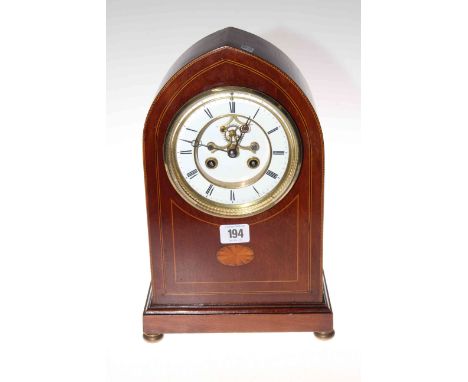 Edwardian inlaid mahogany arch top mantel clock with enamel and brass dial and visible escapement.