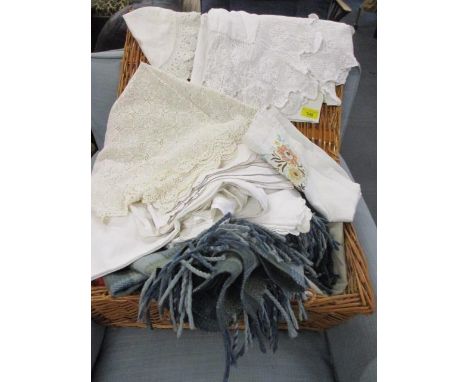A hamper containing vintage linen, napkins and a woollen rug 