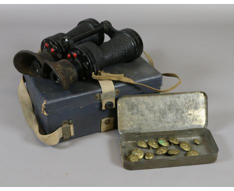 A cased pair of military issue binoculars, stamped X5 Bino Prism MK IV with broad arrow mark, along with a tin of brass milit