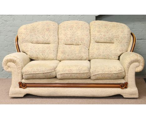 A contemporary three seater sofa with flower upholstery.