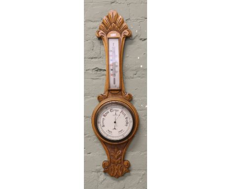A C20th oak banjo barometer with thermometer to upper section, heavily carved throughout.