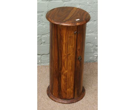 An Indian hardwood drum table with cupboard.