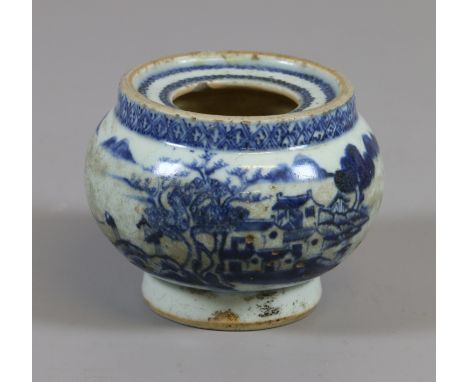 A 19th century Chinese inkwell. Painted in underglaze blue with a continuing landscape incorporating buildings, a bridge and 