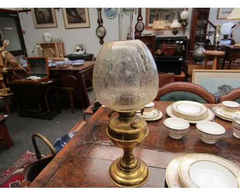 A brass based oil lamp with etched glass shade 