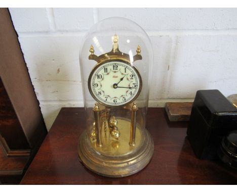 A vintage Kundo torsion clock under glass dome