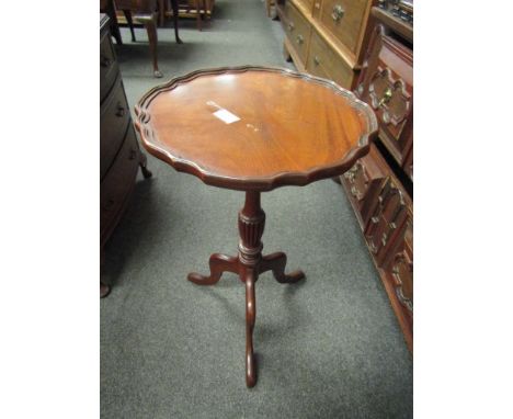 A reproduction mahogany tripod table with fluted support