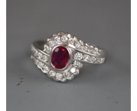 A modern stylish 18ct white gold, ruby and diamond oval cluster ring, with diamond set shoulders, size L/M.