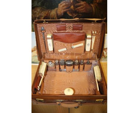 A HAND STITCHED LIGHT TAN TRAVEL CASE AND CONTENTS, the case being unmarked but some pieces such as writing pad holder and co