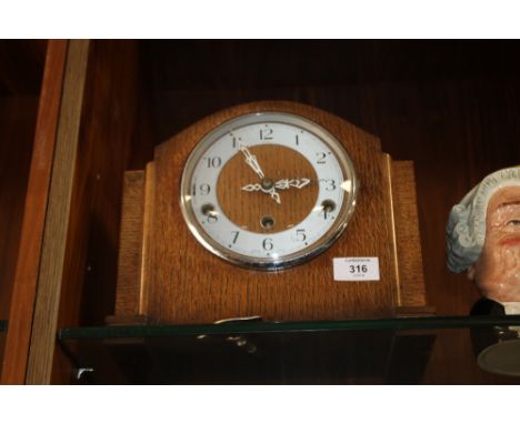 A VINTAGE OAK CASED MANTLE CLOCK