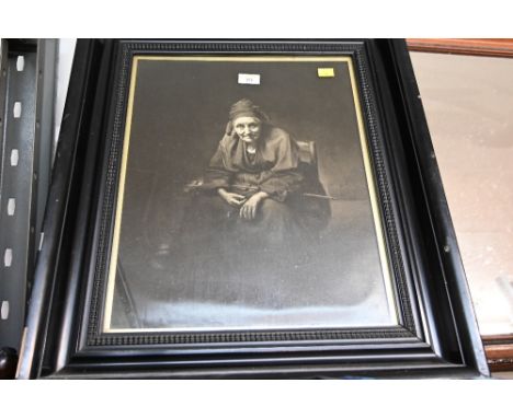 A framed print of an old lady in black frame 