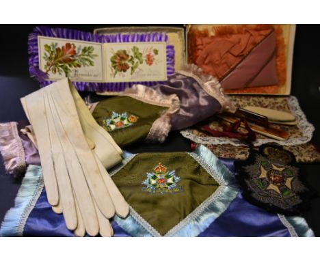 A tub of Military Regiment embroidered items and vintage gloves 