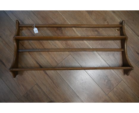 An ercol style oak hanging shelf rack 