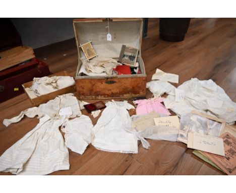 A vintage domed trunk containing dolls clothing