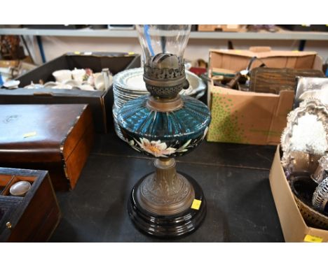 An oil lamp with blue glass reservoir decorated with flowers 