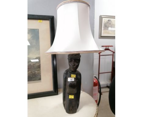 An ethnic inspired table lamp with white shade