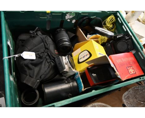 A box of cameras and accessories to include a Cannon lens, Nikon camera, vintage developing items