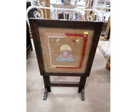An oak tilt top fire screen with embroidered panel 