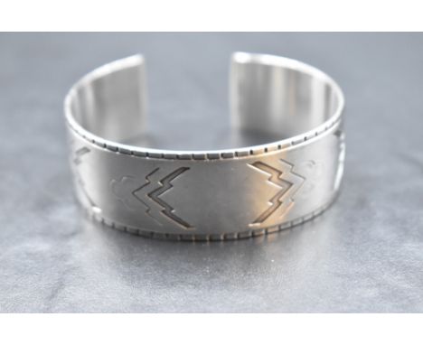A Georg Jensen Danish silver cuff bangle no: 38 designed by Harald Nielsen having lightning bolt and cloud Aztec design, bear