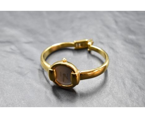 A lady's Gucci gold plated bangle watch no: 0027991, having plain white face
