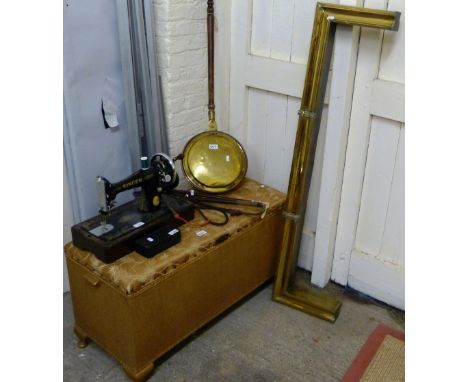 A singer manual sewing machine together with an ottoman, riding crops, brass fender and a brass and copper warming pan
