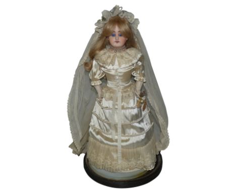 An Armand Marseille German bride doll holding a bouquet of flowers, c.1885, numbered '3097', with china porcelain face and le