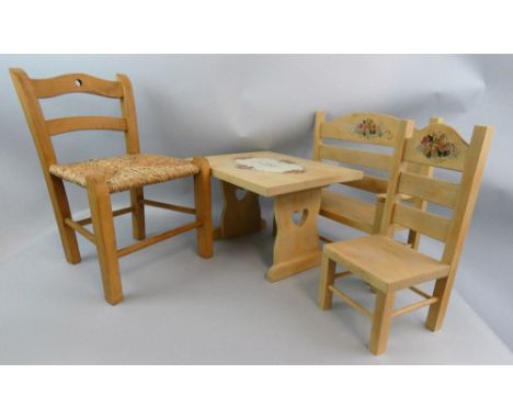 A selection of dolls furniture, to include a handpainted bench, table and single chair, with teddy bear sitting on a flowerbe