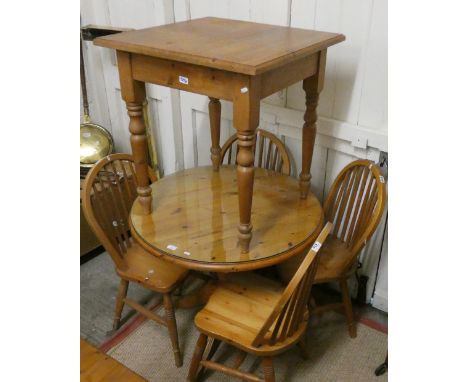 A pine circular dining table with glazed cover together with a set of four stick back chairs and a further square pine table 