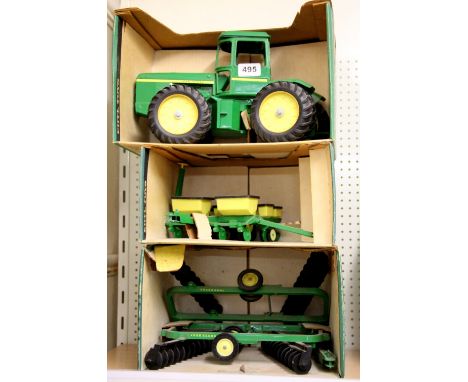 A large John Deere diecast model tractor, corn planter and power disc.