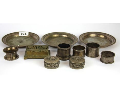 Five hallmarked silver napkin rings, two white metal pill boxes, three Chritsofle white metal dishes and a brass inkwell.