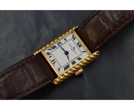 An 18ct gold Baume &amp; Mercier wristwatch, the rectangular white dial having Roman numerals, in a rope motif 18ct gold case