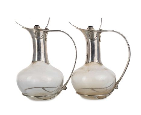 PAIR OF ARTS & CRAFTS STYLE SILVER MOUNTED GLASS CLARET JUGS, GUILD OF HANDICRAFT, LONDON 2002 each with hinged cover set wit