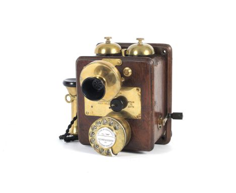 A GPO Bellset No 20. In a wall or table mounted wooden case with rotary dial, brass mouth piece and sperate ear phone convert