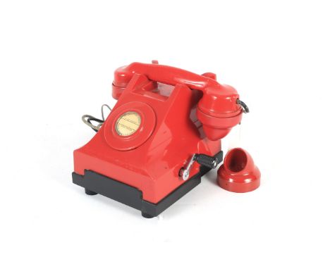 A vintage red party line telephone. With bell set and crank handle on the side, N2123A1 F195 printed on the base, with a red 