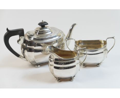 George V silver three piece tea service, Chester 1930/31, comprising teapot with ebony finial and handle, sugar basin and mil