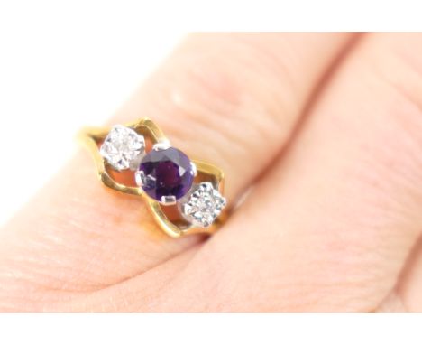 Amethyst and diamond three stone ring, the central round cut amethyst flanked by two small round brilliant cut diamonds in an