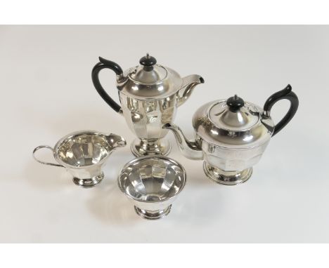 George V silver four piece tea service, London 1933, comprising teapot and hot water jug with ebonised finial and handle, sug