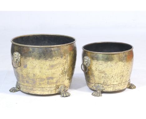 Two similar brass log or coal bins, each of circular form with lions mask ring handles, raised on paw feet, 52cm  and 42cm di