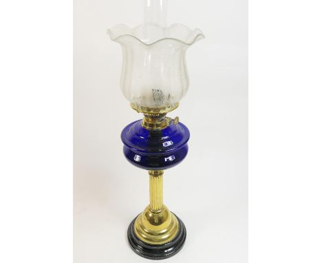 Victorian pedestal oil lamp, with an etched tulip bowl over a blue glass tank and brass reeded column and domed foot with bla