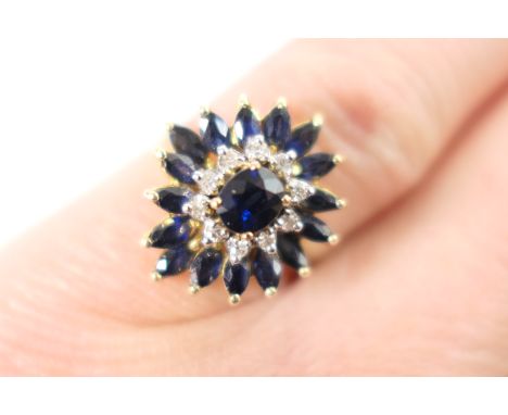 Sapphire and diamond cluster ring, the central oval cut sapphire bordered with tiny round brilliant cut diamonds and with an 